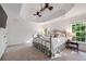 Spacious main bedroom featuring a tray ceiling with ceiling fans, neutral carpet, and large windows at 7115 Doncaster Ct, Cumming, GA 30040