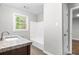 Bathroom featuring granite countertop vanity, modern fixtures, and window for natural light at 2487 Highland Se Dr, Conyers, GA 30013