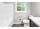 Bathroom featuring a white tub/shower combo, modern vanity, and bright window at 2487 Highland Se Dr, Conyers, GA 30013