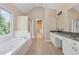 Bright bathroom with soaking tub, vanity, and walk-in closet access at 3355 Golfe Links Dr, Snellville, GA 30039
