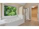 Bright bathroom featuring a soaking tub and separate shower at 3355 Golfe Links Dr, Snellville, GA 30039