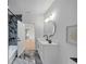 Modern bathroom with marble floors, a black shower, and a white vanity with a round mirror at 3562 Clubland Dr, Marietta, GA 30068