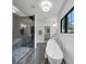 Modern bathroom featuring glass shower, soaking tub, marble flooring, and natural light from the black frame window at 3562 Clubland Dr, Marietta, GA 30068