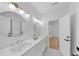 Bathroom with dual sinks, modern lighting, and a doorway to another room with hardwood flooring at 3562 Clubland Dr, Marietta, GA 30068