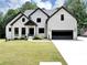 Charming white brick home boasts a well-manicured lawn and a modern, dark garage door at 3562 Clubland Dr, Marietta, GA 30068