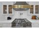 A modern range and hood stand out against quartz countertops and custom cabinets in this stylish kitchen at 3562 Clubland Dr, Marietta, GA 30068