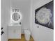 Stylish powder room featuring a modern vanity, round mirror, and elegant wall art at 3562 Clubland Dr, Marietta, GA 30068