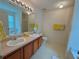 Bright bathroom with double sinks, a large mirror, and a separate toilet area for convenience at 105 Avonwood Cir, Locust Grove, GA 30248