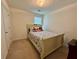 Cozy bedroom featuring a queen bed with a floral comforter, a window, and neutral carpet at 105 Avonwood Cir, Locust Grove, GA 30248