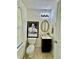 Stylish powder room featuring an oval mirror, elegant lighting, and a black vanity cabinet at 105 Avonwood Cir, Locust Grove, GA 30248