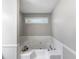 Well-lit bathtub with a small window, white ceramic tile, and a relaxing atmosphere at 30 Court S, Ellenwood, GA 30294