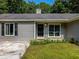 Close up of the home’s entrance with a black door, manicured landscaping, and gray siding at 30 Court S, Ellenwood, GA 30294