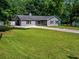 Well-maintained front yard with a lush green lawn and mature trees, creating a welcoming curb appeal at 30 Court S, Ellenwood, GA 30294
