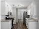 Galley kitchen boasting white cabinets, granite countertops, stainless steel appliances, and modern fixtures at 30 Court S, Ellenwood, GA 30294