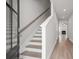 Inviting hallway with wood floors leading to stairs and a view of the living room fireplace at 4778 Moonstone Trce, Kennesaw, GA 30144