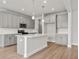 Island kitchen featuring modern lighting, counter seating, and gray cabinets at 4778 Moonstone Trce, Kennesaw, GA 30144