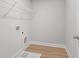 Practical laundry room with wood-look flooring and white wire shelving for storage at 4778 Moonstone Trce, Kennesaw, GA 30144