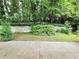 Lush backyard featuring mature trees, green grass, and a concrete patio area at 813 Crockett Ct, Decatur, GA 30033