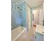 Tiled bathroom showcasing blue tile, patterned wallpaper, and a shower-tub combo at 813 Crockett Ct, Decatur, GA 30033