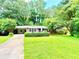 Charming single-story home with a well-maintained lawn and mature trees at 813 Crockett Ct, Decatur, GA 30033