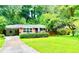 Charming brick home with a well-maintained lawn and beautiful mature trees surrounding the property at 813 Crockett Ct, Decatur, GA 30033