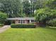 Charming brick home featuring a well-manicured front lawn and mature trees, providing a peaceful setting at 813 Crockett Ct, Decatur, GA 30033