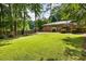 Lush backyard showcases a level lawn, mature trees, wooden fence, and a deck for outdoor gatherings and relaxation at 2163 Medfield Ne Trl, Chamblee, GA 30345