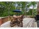 Backyard wooden deck with patio furniture, a blue umbrella, and string lights at 2163 Medfield Ne Trl, Chamblee, GA 30345