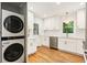 Renovated kitchen with stainless steel appliances, white cabinetry, and a stacked washer and dryer at 2163 Medfield Ne Trl, Chamblee, GA 30345