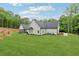 Expansive backyard with lush lawn, mature trees, and rear exterior of home at 540 Byrd Mountain Ln, Canton, GA 30114