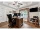 An office with hardwood floors and a ceiling fan, featuring a large desk and comfortable leather chairs at 540 Byrd Mountain Ln, Canton, GA 30114
