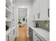 Hallway butler's pantry with marble countertop, wine fridge, and white cabinetry at 6175 River Shore Pkwy, Atlanta, GA 30328