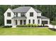 Elegant two-story home with white brick, black trim, manicured lawn and a two-car garage at 6175 River Shore Pkwy, Atlanta, GA 30328