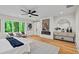 Primary bedroom with modern fireplace, wood floors, and scenic outdoor view at 6175 River Shore Pkwy, Atlanta, GA 30328