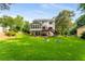 Expansive backyard with lush green grass, garden beds, and a view of the house with a deck and sunroom at 2401 Stockton Dr, Marietta, GA 30066