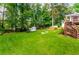 Backyard featuring well-maintained lawn, mature trees, and stairs leading to the deck at 2401 Stockton Dr, Marietta, GA 30066