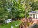 A backyard view with a deck, storage shed, and stairs leading down to the patio, garden beds, and trees at 2401 Stockton Dr, Marietta, GA 30066