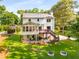 Back of the home with a deck, sunroom, and patio overlooking the well-manicured backyard and landscaping at 2401 Stockton Dr, Marietta, GA 30066