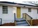 Side entrance featuring a yellow door, wood railing, and white vinyl siding at 2895 Akron St, Atlanta, GA 30344