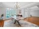 Elegant dining room with hardwood floors, a modern table, and natural light from shuttered windows at 4030 Greatwood Path, Alpharetta, GA 30005