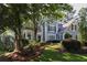 Two-story home featuring manicured landscaping on a sloped front lawn with mature trees at 4030 Greatwood Path, Alpharetta, GA 30005