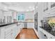 Bright kitchen with white cabinetry, stainless appliances, granite countertops and hardwood floors at 4030 Greatwood Path, Alpharetta, GA 30005