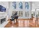 Grand living room with a piano, fireplace, and soaring windows offering serene views at 4030 Greatwood Path, Alpharetta, GA 30005