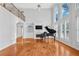 Sunlit living room showcasing a grand piano, fireplace, and expansive windows with views at 4030 Greatwood Path, Alpharetta, GA 30005