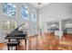 Spacious living room with a piano, tall windows, and an open view into the kitchen at 4030 Greatwood Path, Alpharetta, GA 30005