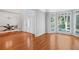Open-concept living area with hardwood floors, large windows, and an adjoining dining room at 4030 Greatwood Path, Alpharetta, GA 30005
