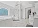 Bright main bathroom with marble floors, glass enclosed shower, and soaking tub at 4030 Greatwood Path, Alpharetta, GA 30005