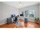 Bright home office with hardwood floors, dual monitors, and natural light from the windows at 4030 Greatwood Path, Alpharetta, GA 30005