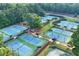This aerial shot highlights meticulously maintained tennis courts amidst beautiful landscaping and mature trees at 4030 Greatwood Path, Alpharetta, GA 30005