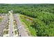 Aerial view of a residential street with houses and a pond surrounded by greenery at 4189 Brookmont Way, Auburn, GA 30011